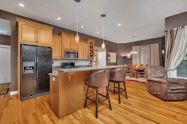 300 Village Ln, Seneca, IL 61360 - kitchen with black fridge with ice dispenser, stainless steel microwave, light wood-type flooring, a breakfast bar, and glass insert cabinets