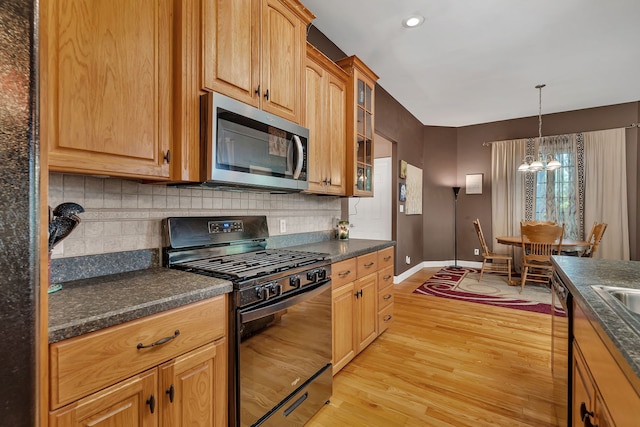 300 Village Ln, Seneca, IL 61360 - kitchen with black gas range oven, stainless steel microwave, dark countertops, light wood-type flooring, and recessed lighting