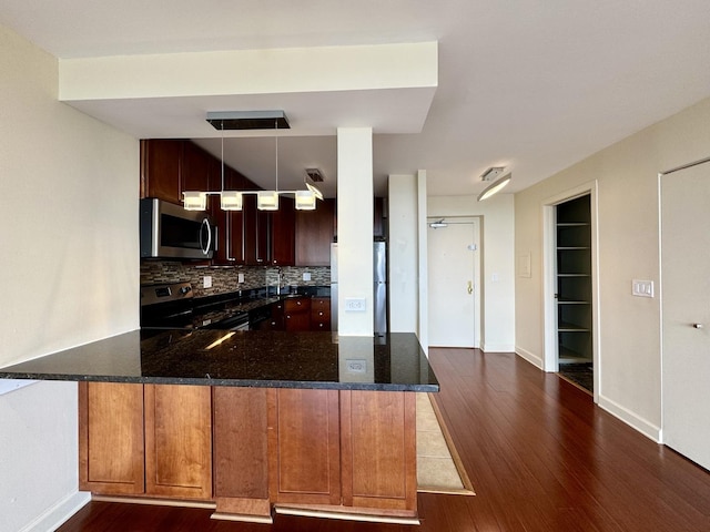 1850 N Clark St Unit 2706, Chicago, IL 60614 - kitchen with appliances with stainless steel finishes, dark wood-style floors, backsplash, dark stone counters, and pendant lighting
