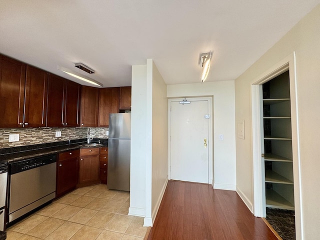 1850 N Clark St Unit 2706, Chicago, IL 60614 - kitchen with stainless steel appliances, dark countertops, backsplash, and light tile patterned flooring