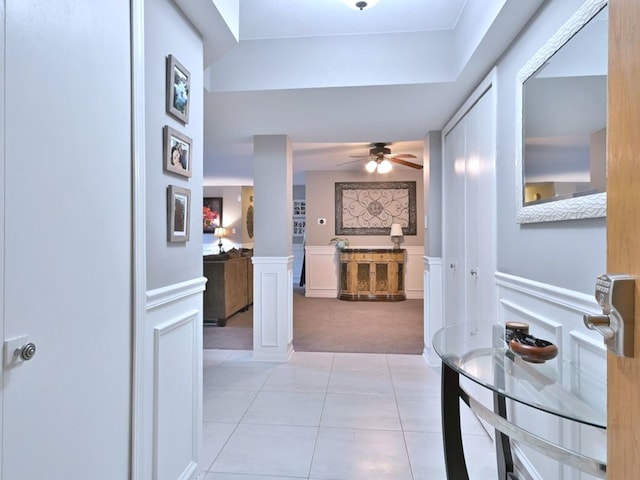 14031 Norwich Ln Unit 101, Orland Park, IL 60467 - hallway featuring light colored carpet, light tile patterned flooring, wainscoting, a decorative wall, and ornate columns