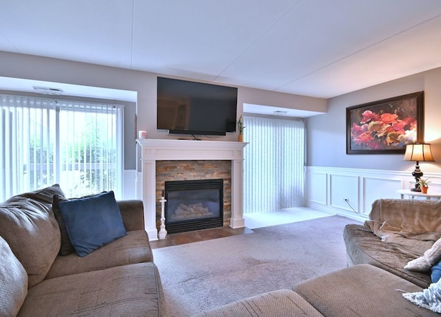 14031 Norwich Ln Unit 101, Orland Park, IL 60467 - living area with plenty of natural light, a stone fireplace, a wainscoted wall, and a decorative wall