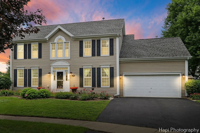 768 Wexford Ct, Grayslake, IL 60030 - colonial-style house with asphalt driveway, an attached garage, a shingled roof, and a front yard