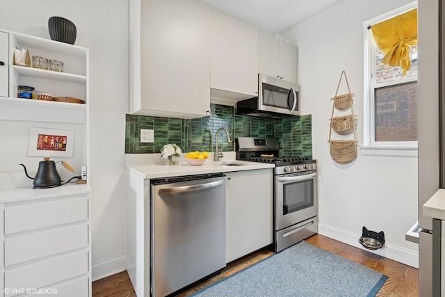 3555 W Lyndale St Unit 3B, Chicago, IL 60647 - kitchen with stainless steel appliances, white cabinets, backsplash, light countertops, and wood finished floors