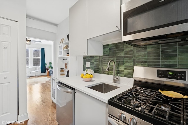3555 W Lyndale St Unit 3B, Chicago, IL 60647 - kitchen with appliances with stainless steel finishes, white cabinets, light countertops, and decorative backsplash