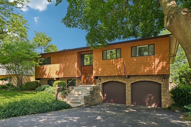 129 Kainer Ave, Barrington, IL 60010 - bi-level home featuring a garage, brick siding, and asphalt driveway