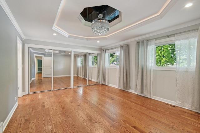129 Kainer Ave, Barrington, IL 60010 - unfurnished bedroom with a tray ceiling, ornamental molding, multiple closets, wood finished floors, and a chandelier