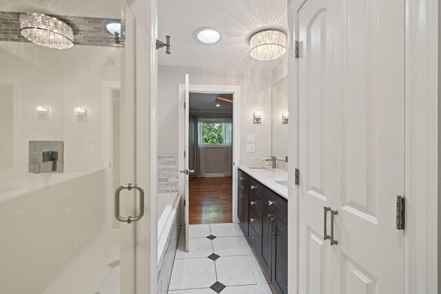 129 Kainer Ave, Barrington, IL 60010 - full bath with a chandelier, tile patterned floors, a stall shower, double vanity, and a bath