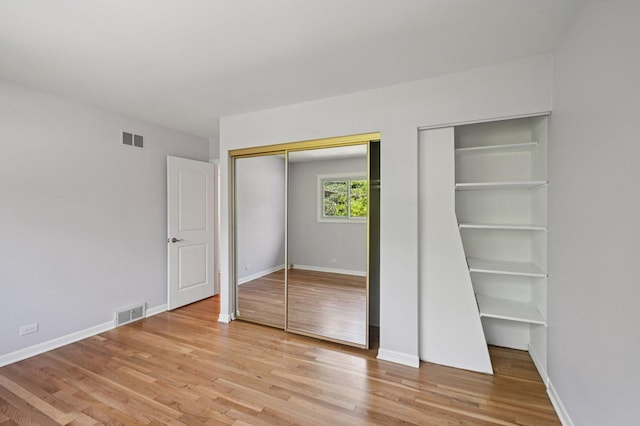 129 Kainer Ave, Barrington, IL 60010 - unfurnished bedroom with light wood-style flooring and two closets