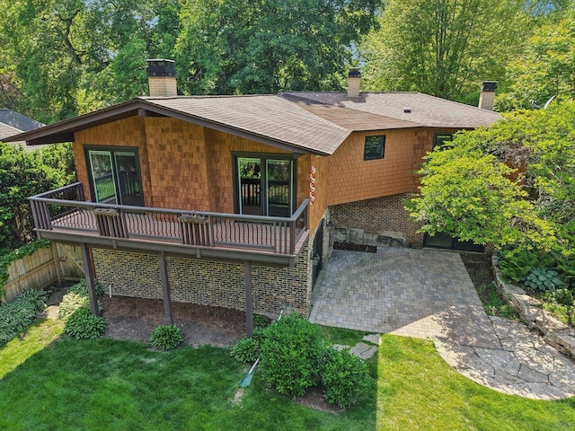 129 Kainer Ave, Barrington, IL 60010 - rear view of house featuring a chimney, a wooden deck, a yard, roof with shingles, and a patio