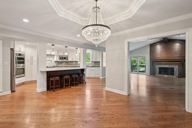 129 Kainer Ave, Barrington, IL 60010 - kitchen with stainless steel appliances, healthy amount of natural light, white cabinetry, a breakfast bar, and ornamental molding