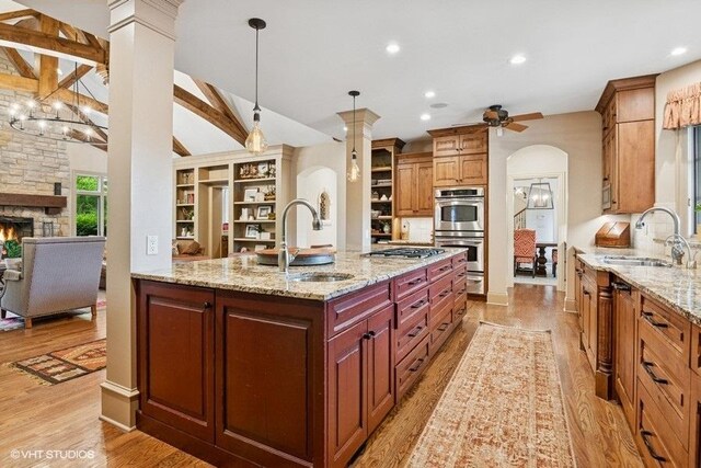41W590 Bowgren Dr, Campton Hills, IL 60119 - kitchen featuring appliances with stainless steel finishes, light wood finished floors, arched walkways, light stone countertops, and ceiling fan