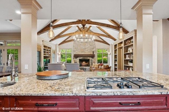 41W590 Bowgren Dr, Campton Hills, IL 60119 - kitchen with reddish brown cabinets, pendant lighting, light stone counters, stainless steel gas cooktop, and a stone fireplace