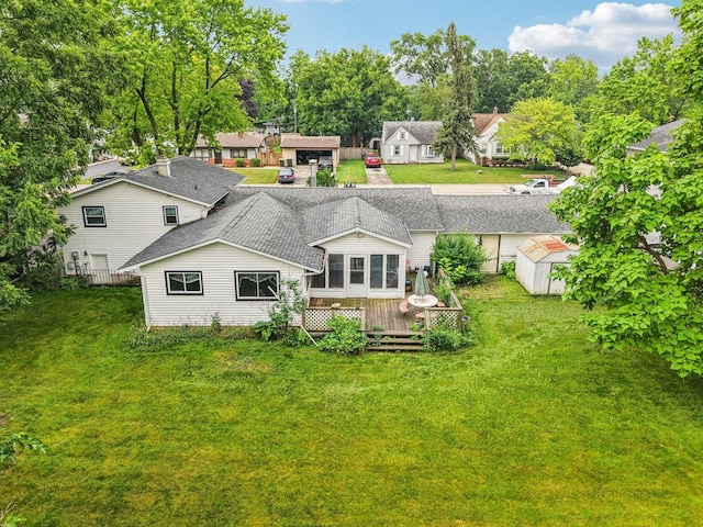 602 Daisy Ln, Round Lake Beach, IL 60073 - back of property featuring a deck, a storage shed, and a lawn