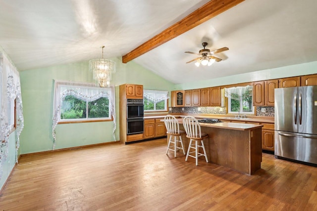 602 Daisy Ln, Round Lake Beach, IL 60073 - kitchen featuring freestanding refrigerator, a center island, brown cabinetry, and backsplash