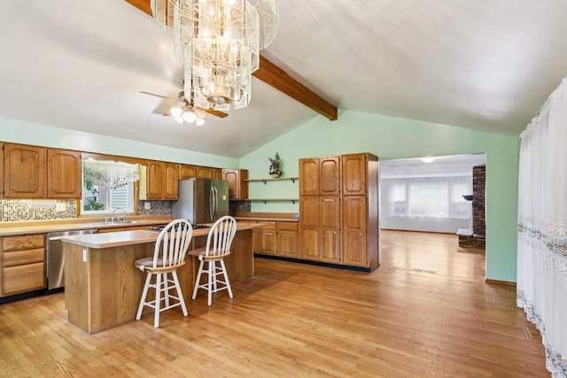 602 Daisy Ln, Round Lake Beach, IL 60073 - kitchen with appliances with stainless steel finishes, a kitchen island, a chandelier, light wood-style floors, and brown cabinetry
