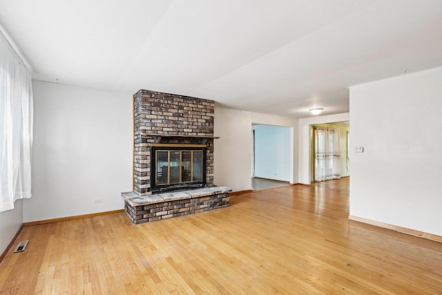 602 Daisy Ln, Round Lake Beach, IL 60073 - unfurnished living room featuring wood finished floors and a fireplace
