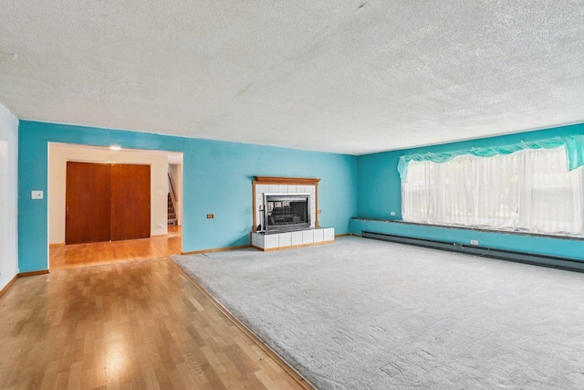 602 Daisy Ln, Round Lake Beach, IL 60073 - unfurnished living room with a textured ceiling, wood finished floors, and a fireplace