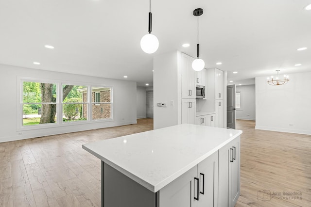 154 Newton Ave, Glen Ellyn, IL 60137 - kitchen featuring stainless steel microwave, open floor plan, light wood finished floors, recessed lighting, and a chandelier