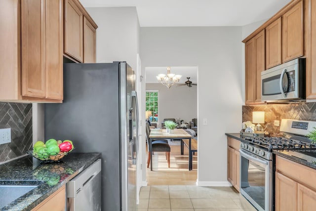 6406 Cunningham Ct, Gurnee, IL 60031 - kitchen with stainless steel appliances, a chandelier, light tile patterned floors, decorative backsplash, and dark stone countertops