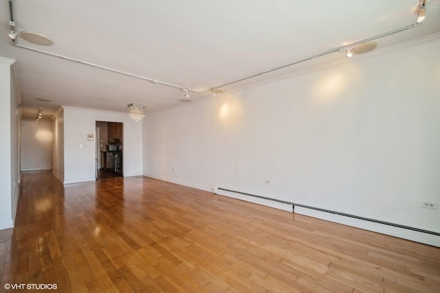 1508 W Pratt Blvd Unit 2C, Chicago, IL 60626 - empty room featuring baseboard heating, crown molding, hardwood / wood-style flooring, and track lighting