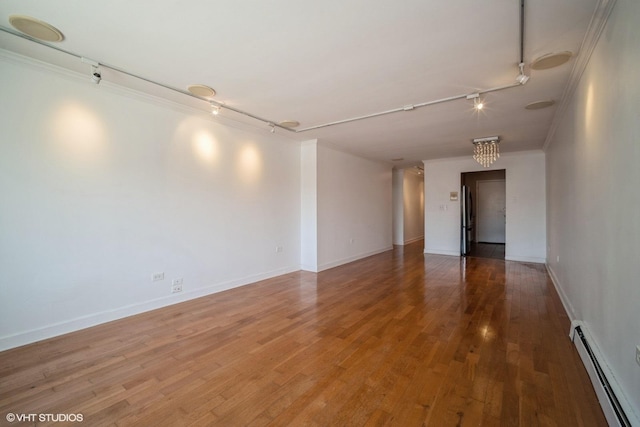 1508 W Pratt Blvd Unit 2C, Chicago, IL 60626 - spare room featuring rail lighting, a baseboard heating unit, crown molding, and wood finished floors