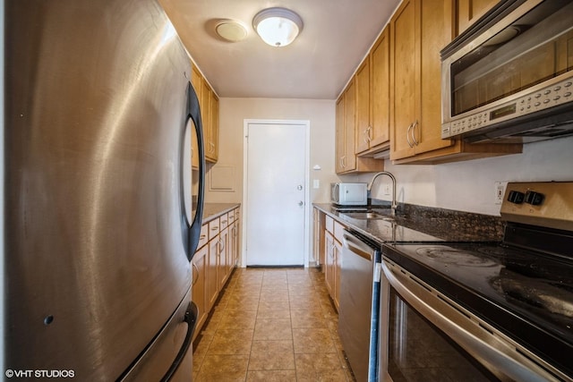 1508 W Pratt Blvd Unit 2C, Chicago, IL 60626 - kitchen featuring appliances with stainless steel finishes, brown cabinets, and dark stone counters