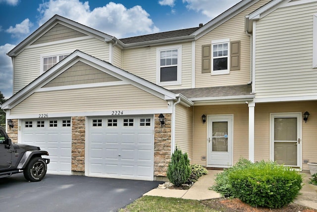 2224 Flagstone Ln Unit 2224, Carpentersville, IL 60110 - view of front of property with driveway, stone siding, and a shingled roof