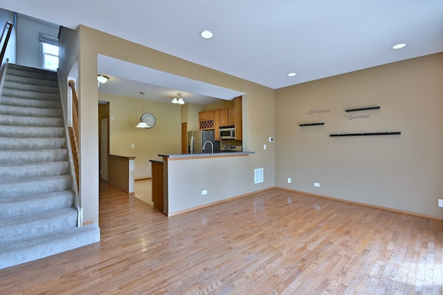2224 Flagstone Ln Unit 2224, Carpentersville, IL 60110 - unfurnished living room featuring light wood-type flooring, stairway, and recessed lighting