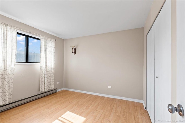 7526 S Cork Ave Unit 7526, Justice, IL 60458 - unfurnished bedroom with baseboard heating, light wood-style floors, and a closet
