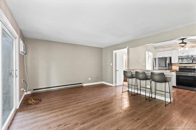 7526 S Cork Ave Unit 7526, Justice, IL 60458 - kitchen featuring stainless steel appliances, a baseboard radiator, white cabinets, a breakfast bar area, and wood finished floors