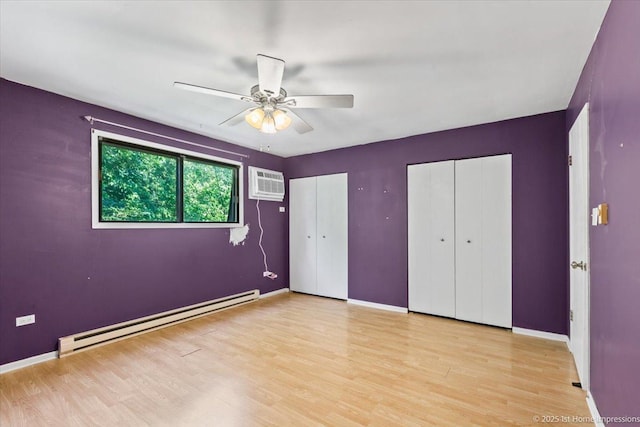 7526 S Cork Ave Unit 7526, Justice, IL 60458 - unfurnished bedroom featuring a baseboard radiator, two closets, a wall unit AC, wood finished floors, and a ceiling fan