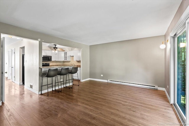7526 S Cork Ave Unit 7526, Justice, IL 60458 - living area featuring baseboard heating, wood finished floors, and a ceiling fan