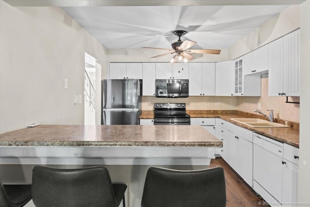 7526 S Cork Ave Unit 7526, Justice, IL 60458 - kitchen with stainless steel appliances, ceiling fan, a kitchen bar, glass insert cabinets, and dark wood-style floors