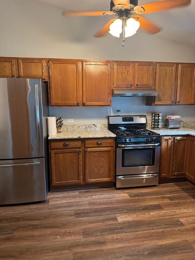 815 Arnold Ave, Rockford, IL 61108 - kitchen with appliances with stainless steel finishes, under cabinet range hood, a ceiling fan, brown cabinets, and vaulted ceiling