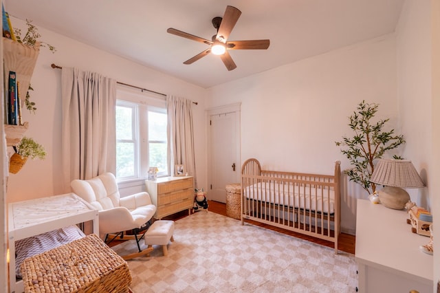 102 E Front St, Mount Morris, IL 61054 - bedroom featuring a nursery area, light wood-type flooring, and a ceiling fan