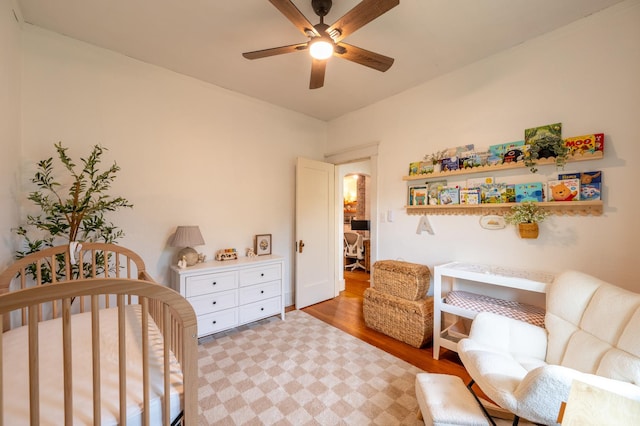 102 E Front St, Mount Morris, IL 61054 - bedroom featuring a nursery area, light wood finished floors, arched walkways, and ceiling fan