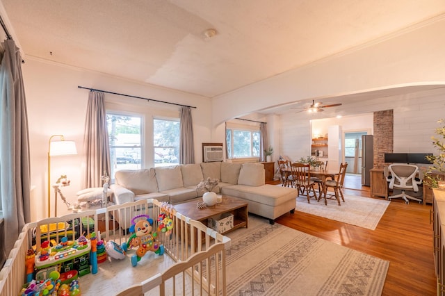 102 E Front St, Mount Morris, IL 61054 - living room with light wood-type flooring, arched walkways, a ceiling fan, ornamental molding, and a wall mounted AC