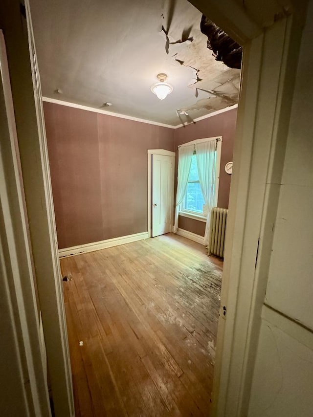 2925 W Eastwood Ave, Chicago, IL 60525 - spare room featuring wood-type flooring, radiator, and crown molding