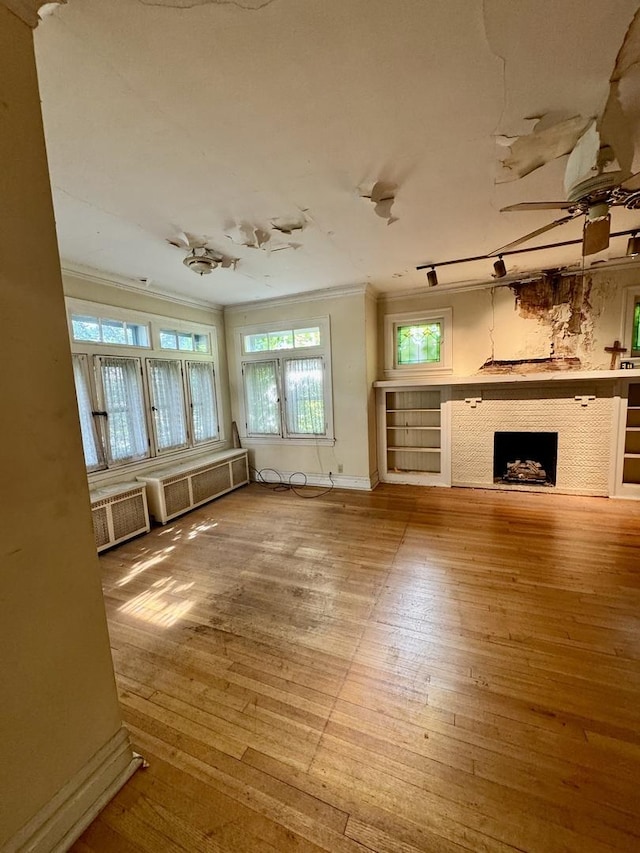 2925 W Eastwood Ave, Chicago, IL 60525 - unfurnished living room featuring crown molding, wood-type flooring, plenty of natural light, and a fireplace