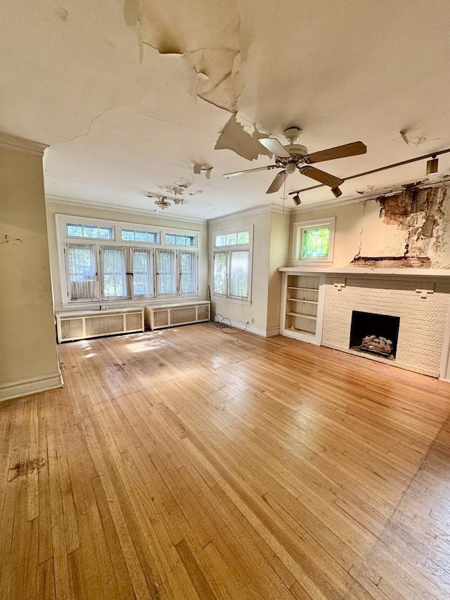2925 W Eastwood Ave, Chicago, IL 60525 - unfurnished living room featuring crown molding, light wood-style flooring, a fireplace, ceiling fan, and radiator heating unit