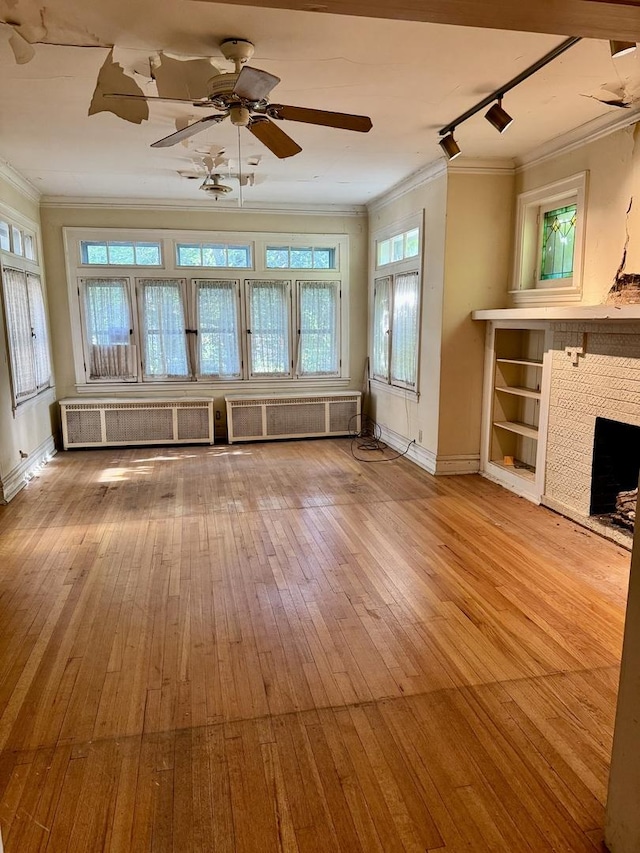 2925 W Eastwood Ave, Chicago, IL 60525 - unfurnished living room with radiator, crown molding, rail lighting, wood-type flooring, and ceiling fan