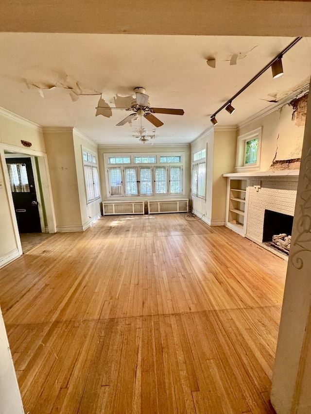 2925 W Eastwood Ave, Chicago, IL 60525 - unfurnished living room with ornamental molding, rail lighting, light wood-style floors, a fireplace, and ceiling fan