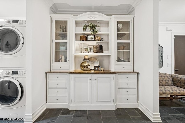 laundry room featuring stacked washer and clothes dryer and ornamental molding