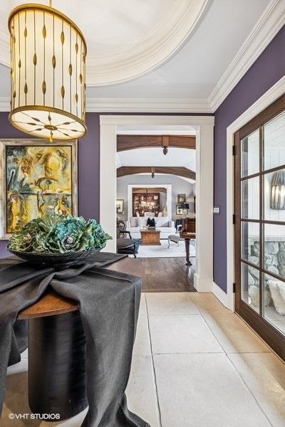 corridor featuring ornamental molding, tile patterned flooring, and plenty of natural light