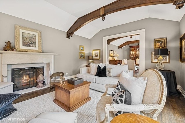 living room featuring vaulted ceiling, wood finished floors, a premium fireplace, and arched walkways