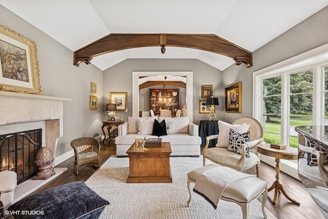 living area with wood finished floors, a chandelier, lofted ceiling, and a fireplace