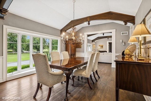 dining room featuring lofted ceiling, wainscoting, a chandelier, dark wood finished floors, and arched walkways