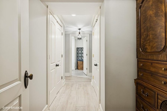 hallway featuring baseboards and light wood finished floors