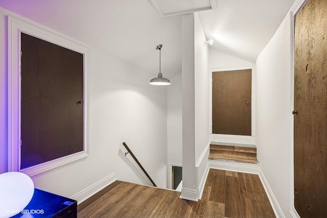 hall featuring an upstairs landing, wood finished floors, and lofted ceiling